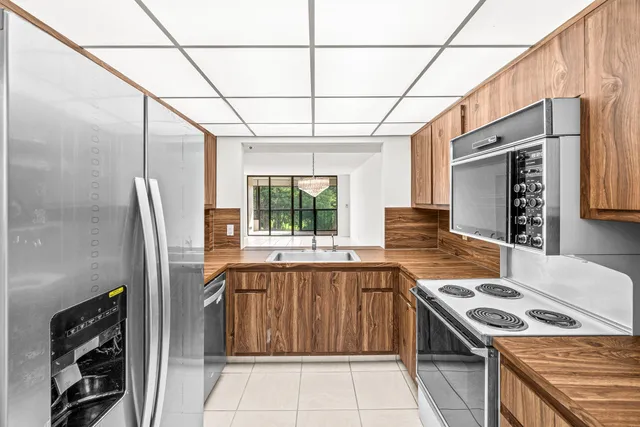 a kitchen that has a sink a stove top oven a refrigerator and a microwave