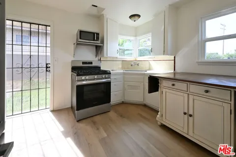 a kitchen with white cabinets and appliances