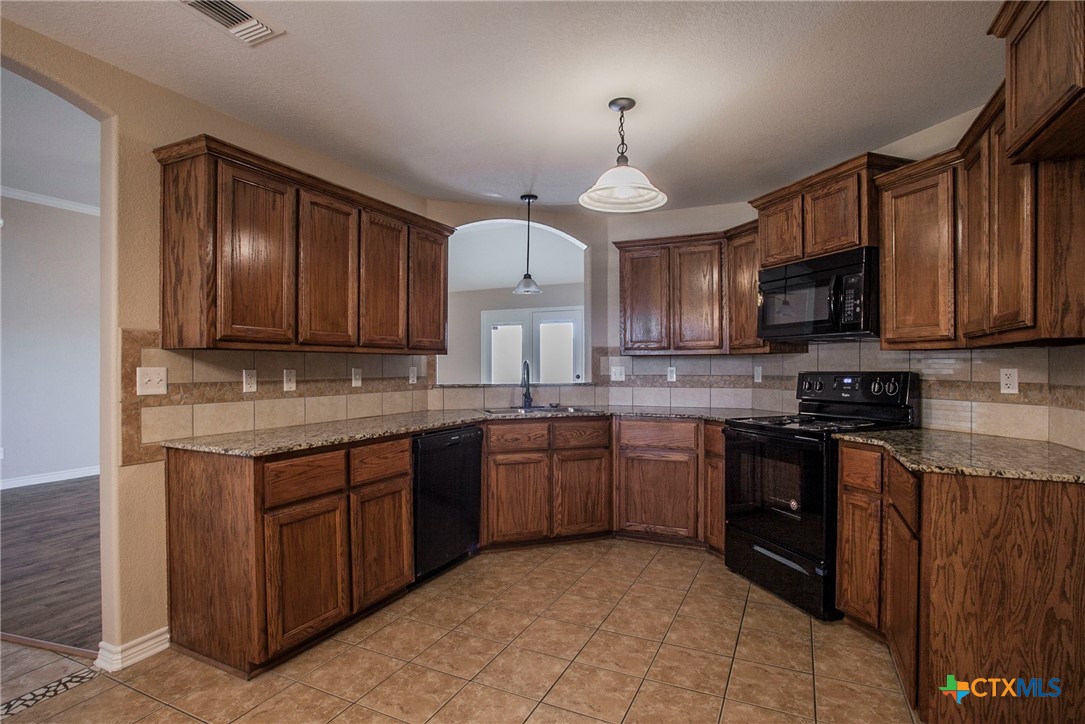 3710 Dewitt County Court Killeen, TX 76549 - Photo 4 of 18 a kitchen with stainless steel appliances granite countertop wooden cabinets granite counter tops and a stove