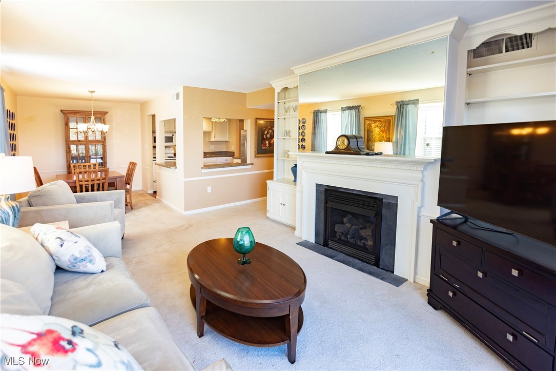 22701 Center Ridge Road, Unit 307 Rocky River, OH 44116 - Photo 9 of 27 Living area with a fireplace with flush hearth and light carpet