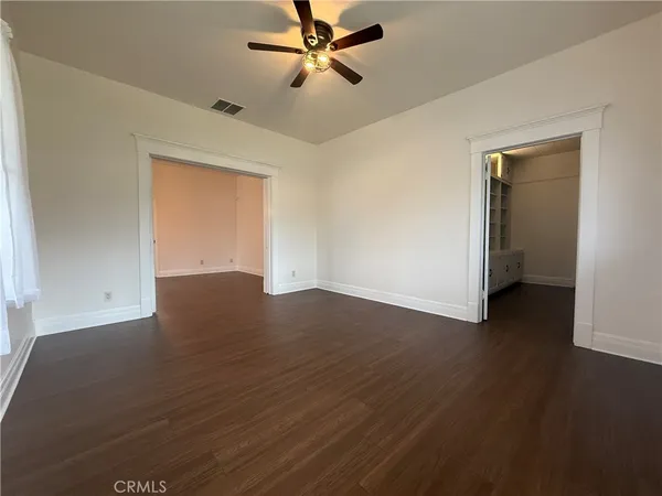 a view of empty room with wooden floor