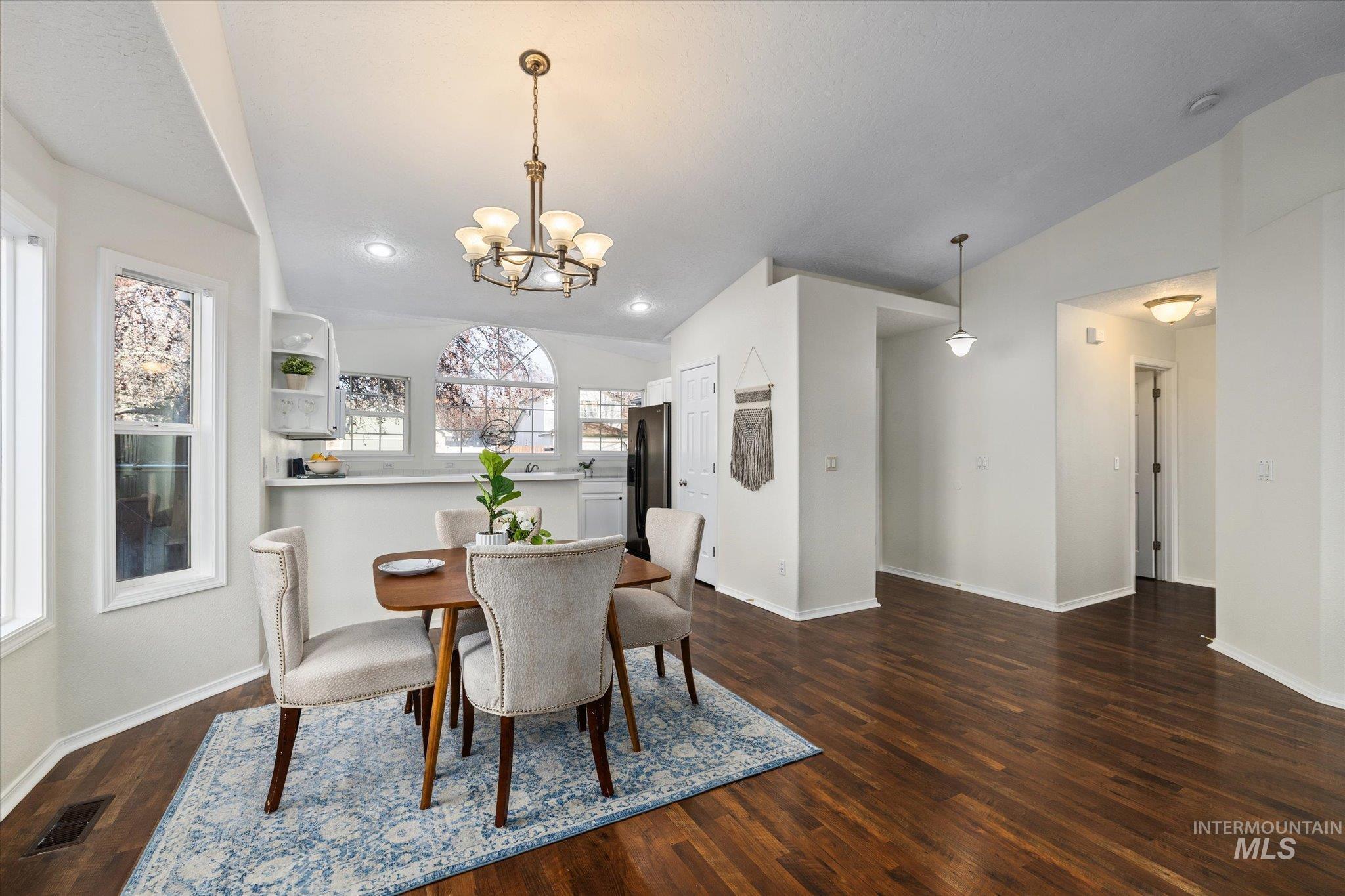 1399 West Gander Drive Meridian, ID 83642 - Photo 12 of 40 Dining room featuring a chandelier, dark wood-type flooring, and lofted ceiling