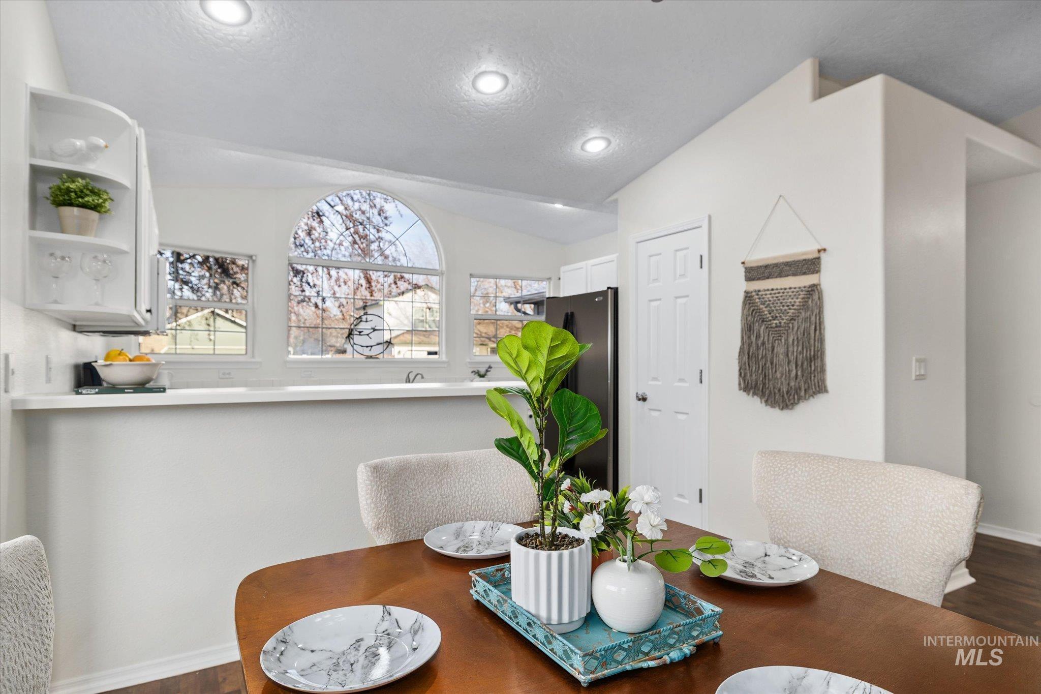1399 West Gander Drive Meridian, ID 83642 - Photo 14 of 40 Dining room with dark wood-style floors, a textured ceiling, lofted ceiling, and recessed lighting