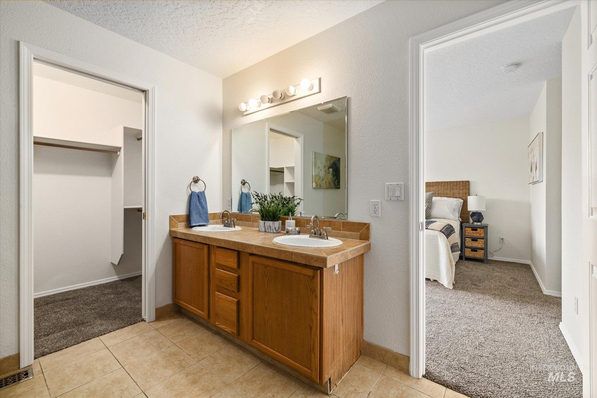1399 West Gander Drive Meridian, ID 83642 - Photo 23 of 40 Full bathroom featuring light colored carpet, double vanity, a textured ceiling, light tile patterned floors, and ensuite bath