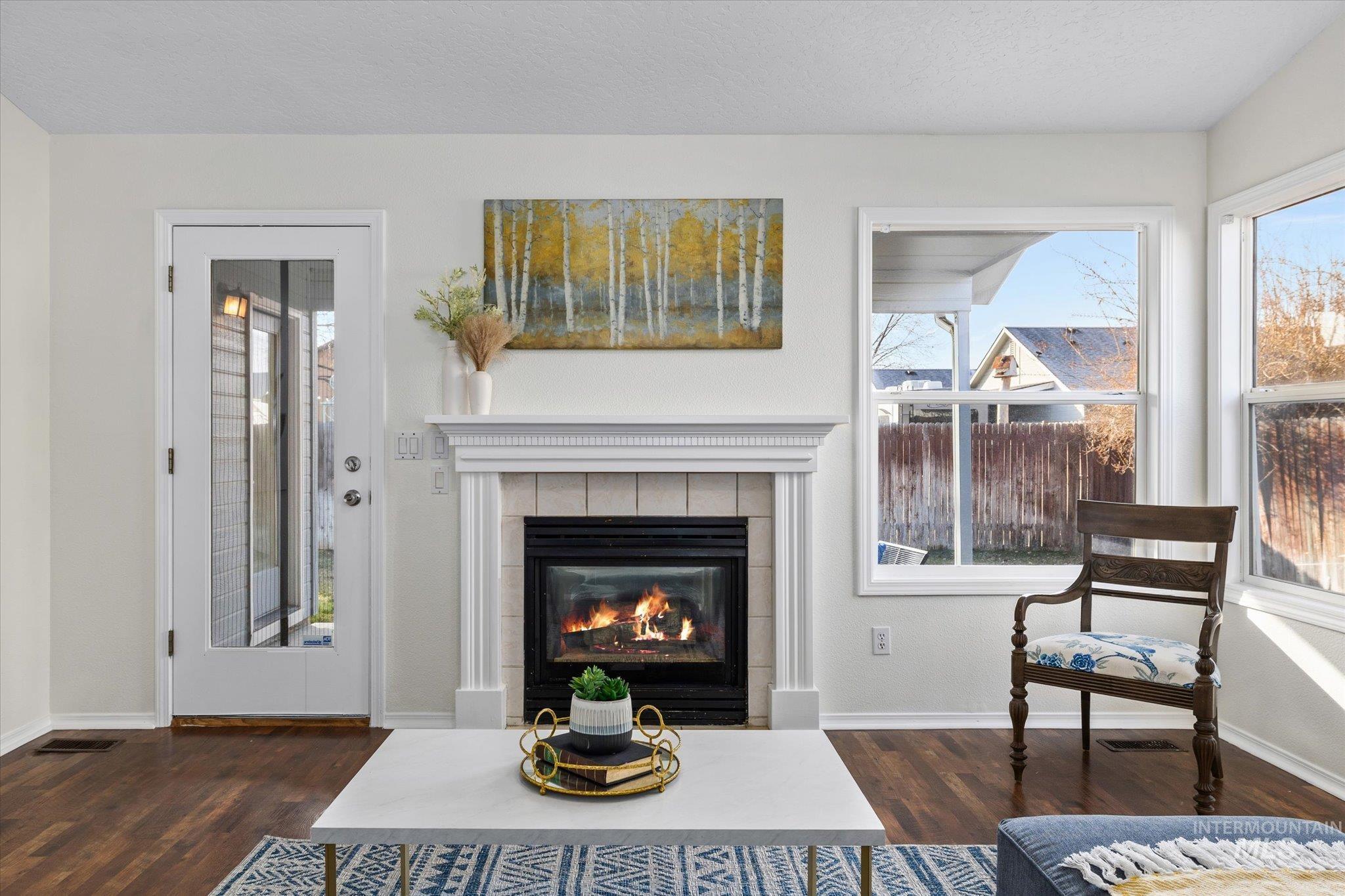 1399 West Gander Drive Meridian, ID 83642 - Photo 9 of 40 Living area with a tiled fireplace and dark wood-style floors