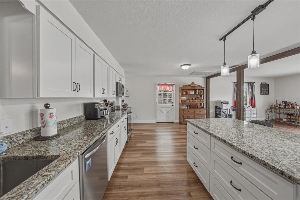 609 West Pipkin Road Lakeland, FL 33813 - Photo 16 of 72 a large kitchen with granite countertop a large counter top cabinets and stainless steel appliances