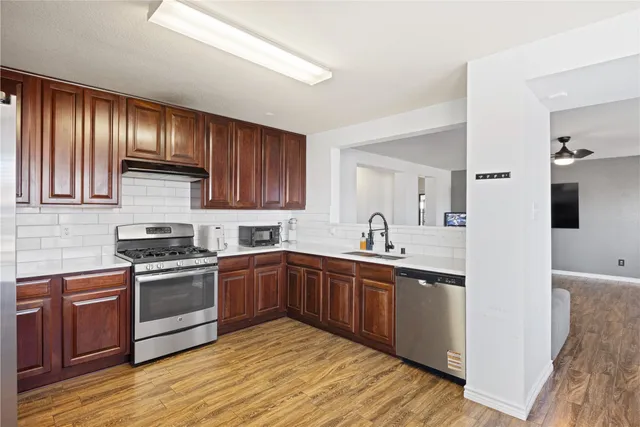 a kitchen with wooden cabinets stainless steel appliances and a sink