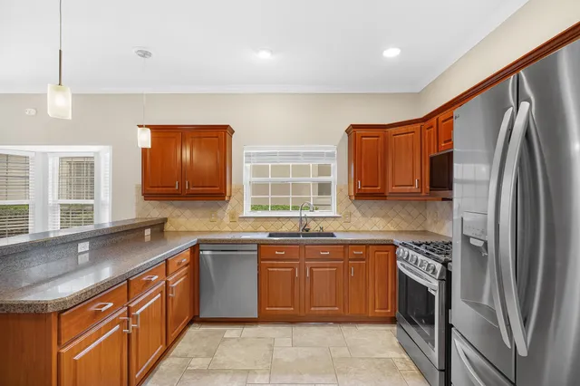 a kitchen with stainless steel appliances granite countertop a sink stove and refrigerator