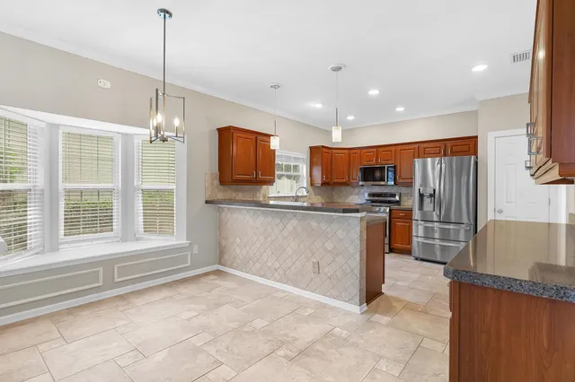 a kitchen with stainless steel appliances granite countertop a refrigerator and microwave