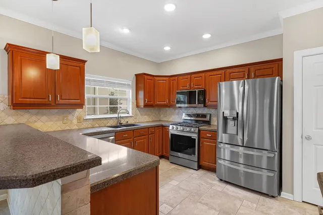 a kitchen with stainless steel appliances granite countertop a sink stove and refrigerator