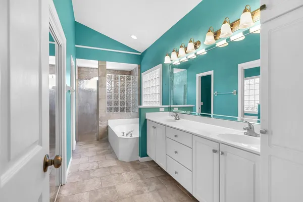 a spacious bathroom with a double vanity sink mirror and a bathtub