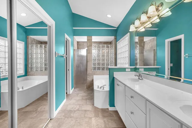 a spacious en suite bathroom with a double vanity sink and a large mirror