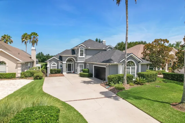 a front view of a house with a garden and yard