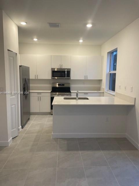 29009 Southwest 162nd Court, Unit 29009 Homestead, FL 33033 - Photo 5 of 26 a kitchen with kitchen island a counter top space cabinets and stainless steel appliances