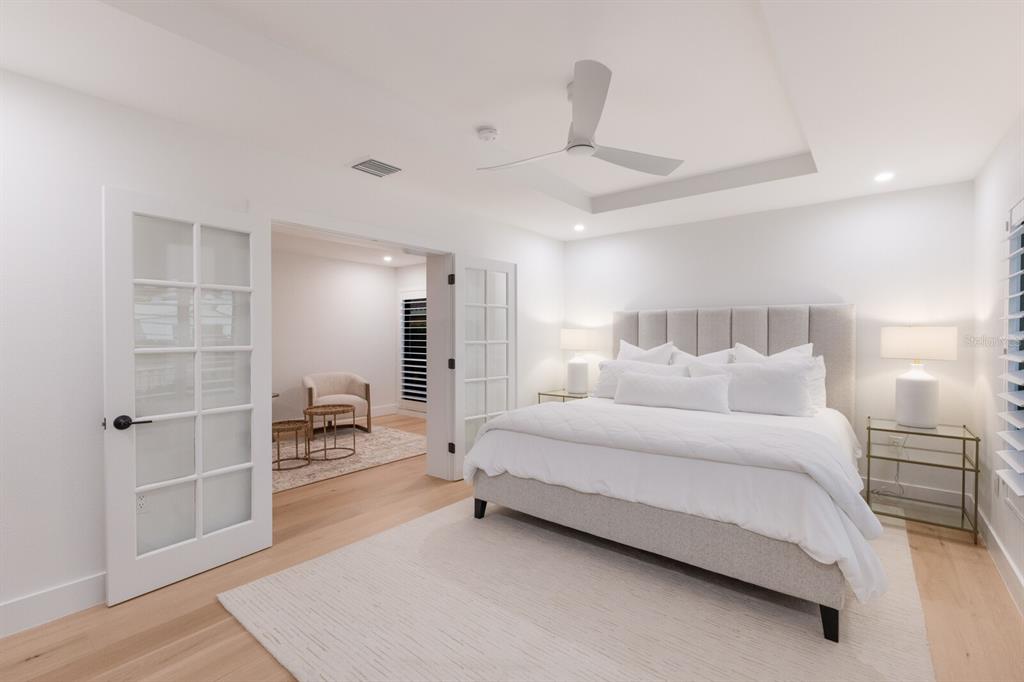 510 Putter Lane Longboat Key, FL 34228 - Photo 13 of 74 a spacious bedroom with a bed a table and potted plant on the table