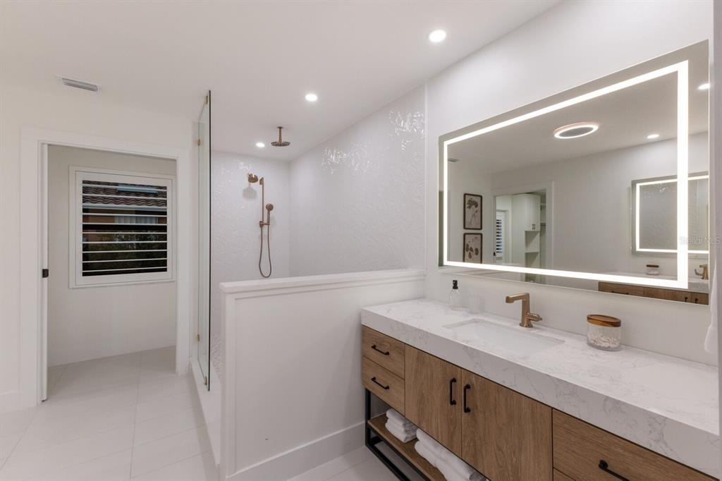 510 Putter Lane Longboat Key, FL 34228 - Photo 16 of 74 a bathroom with a shower sink and mirror