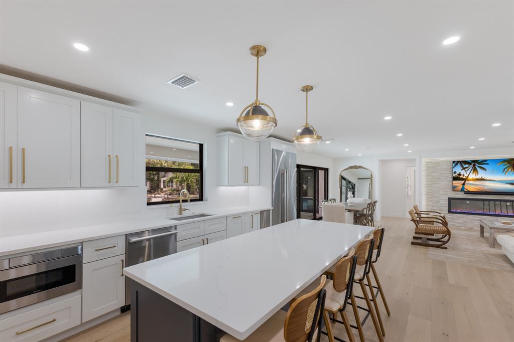 510 Putter Lane Longboat Key, FL 34228 - Photo 44 of 74 a kitchen with stainless steel appliances a kitchen island a stove a table and chairs in it