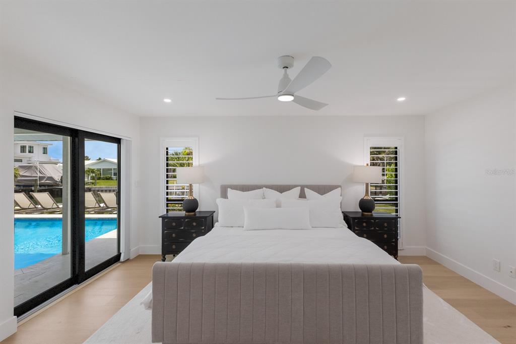 510 Putter Lane Longboat Key, FL 34228 - Photo 58 of 74 a bedroom with a large bed and a chandelier