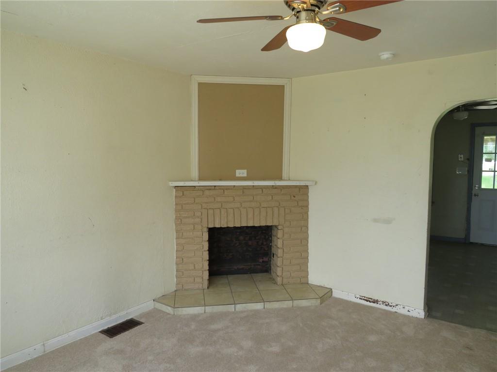 666 Ewing Street Washington, PA 15301 - Photo 2 of 22 an empty room with a fireplace and fan