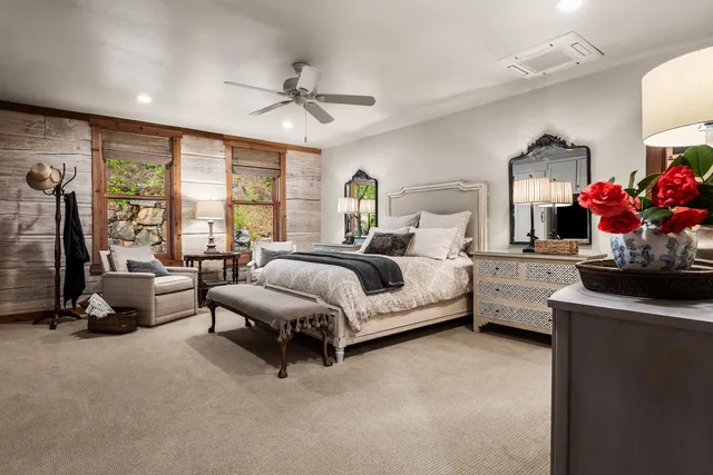 a bedroom with a bed gym equipment and a large window