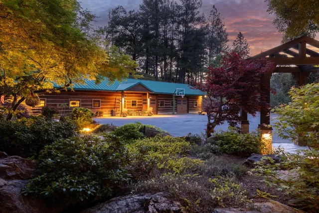 a backyard of a house with lots of plants and tree