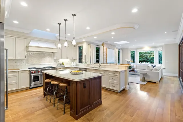 a kitchen with a sink stove and wooden floor