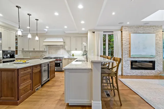 a kitchen with stainless steel appliances kitchen island granite countertop a stove a sink a oven a dining table and chairs