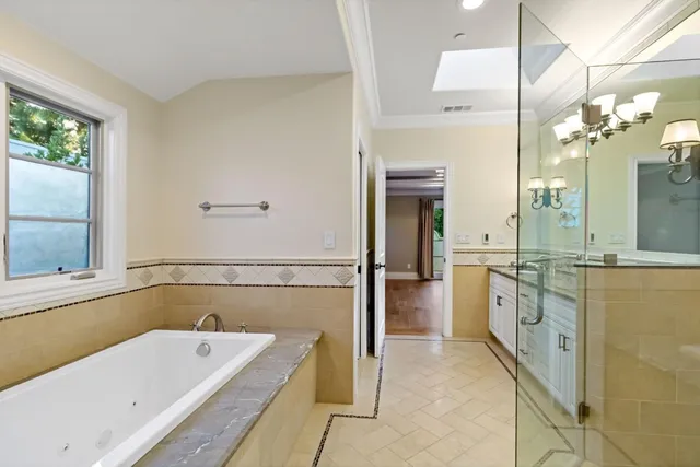 a bathroom with a tub a double vanity sink and mirror