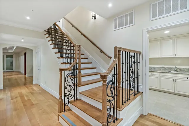 a view of an empty room with wooden floor fireplace and a window