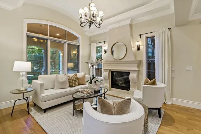 a living room with furniture a chandelier and a fireplace