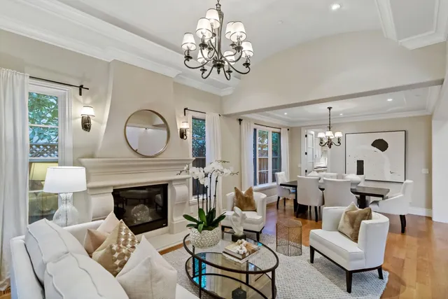 a living room with furniture a fireplace and a chandelier