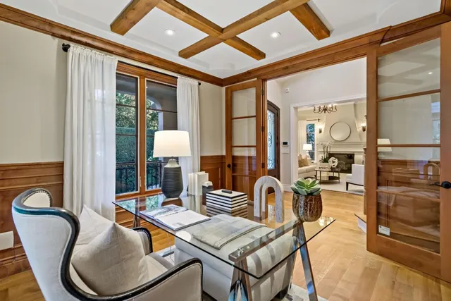 a living room with furniture a flat screen tv and large windows