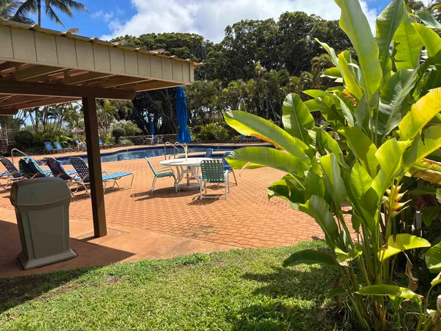 a view of a swimming pool with a patio and a yard