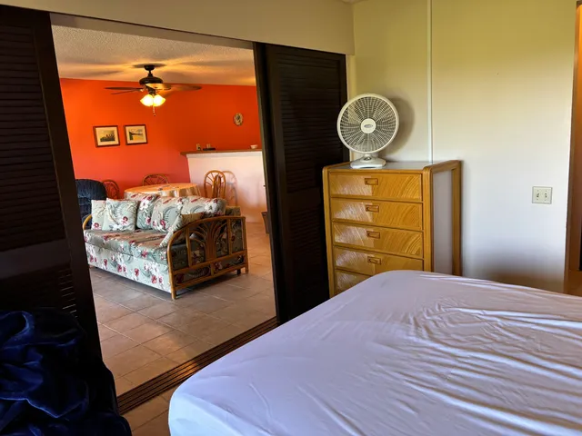 a bedroom with a bed and a lamp on dresser