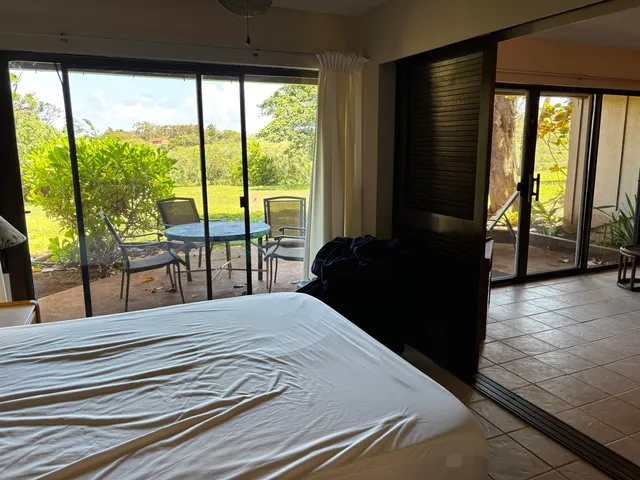 a bedroom with a bed and large windows