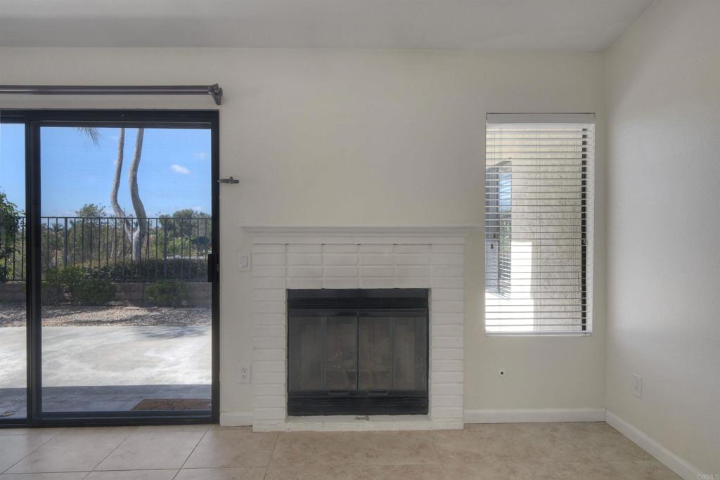 1394 Longfellow Road Vista, CA 92081 - Photo 15 of 50 a living room with a fireplace and a glass door