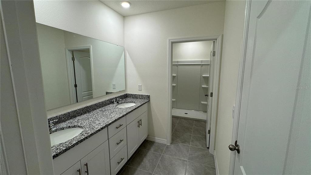 1442 Isleta Loop Kissimmee, FL 34741 - Photo 15 of 28 a bathroom with a granite countertop sink and a mirror