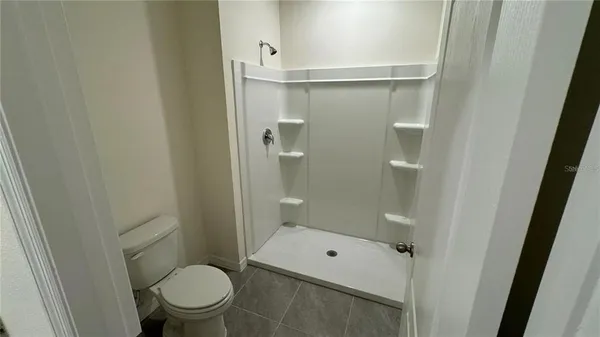 a bathroom with a granite countertop toilet a sink and shower