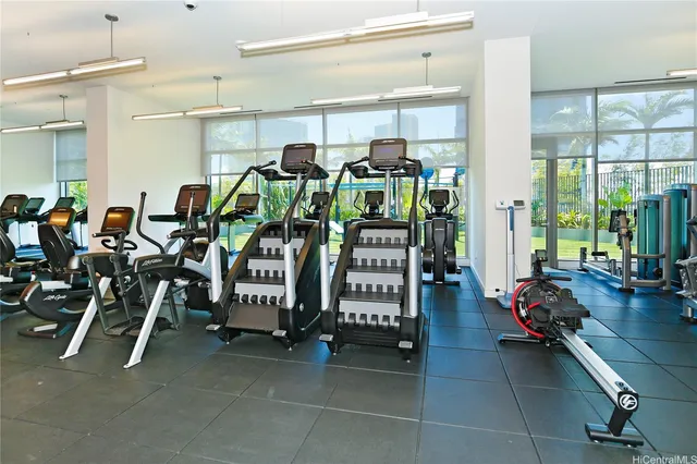 a gym room with gym equipment and large mirror