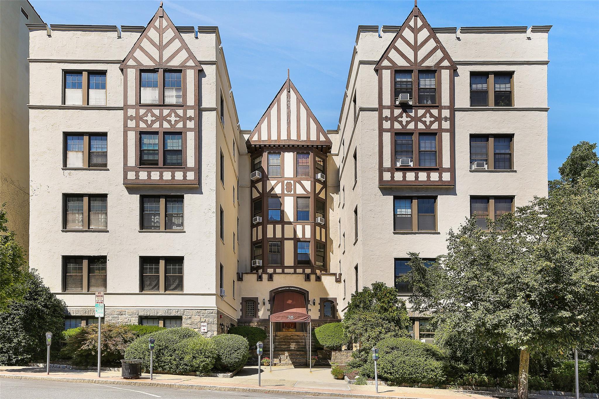26 Pondfield Road West, Unit 2A Bronxville, NY 10708 - Photo 1 of 1 a front view of a residential apartment building with a yard and many windows