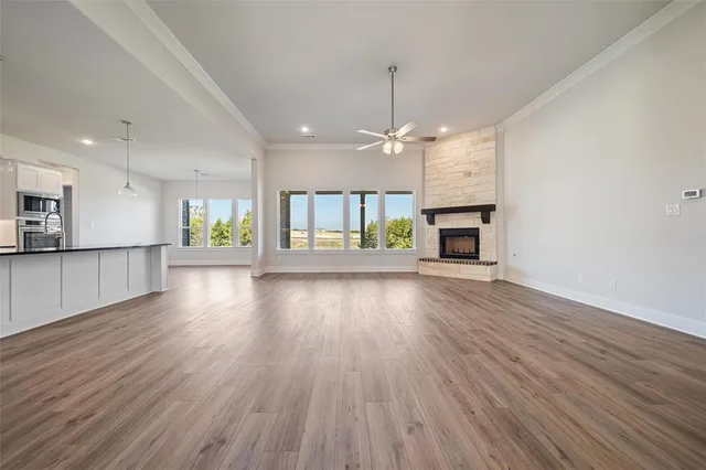 an empty room with a fireplace and wooden floor