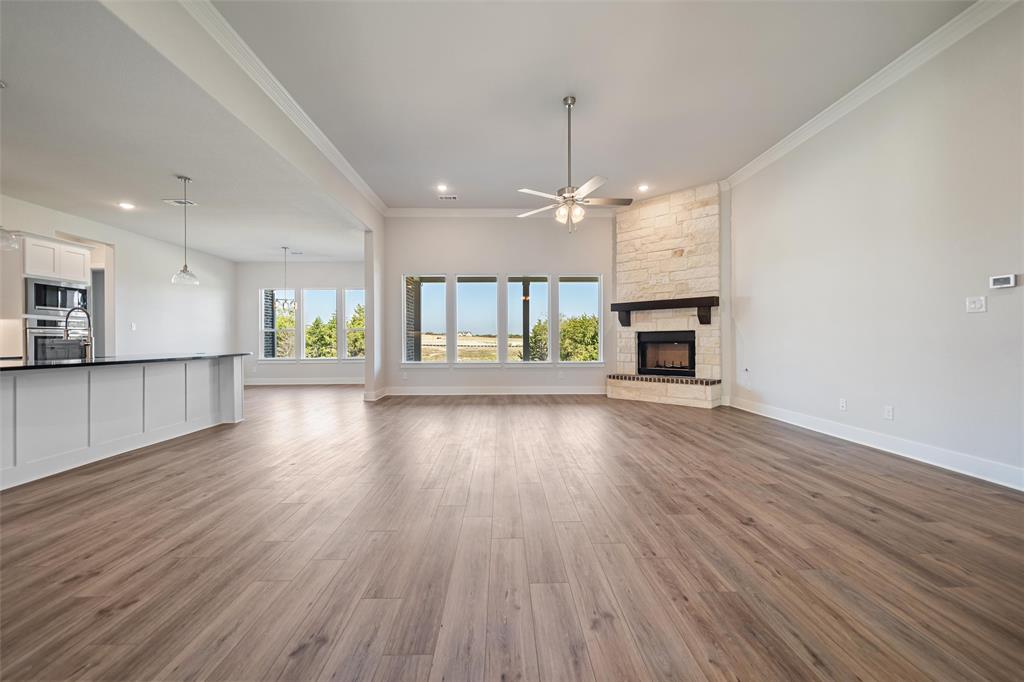 404 Indian Creek Road Van Alstyne, TX 75495 - Photo 12 of 40 an empty room with a fireplace and wooden floor