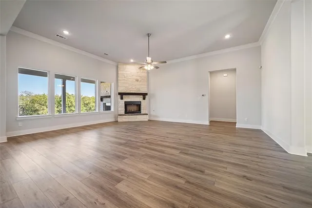 an empty space with wooden floor a chandelier and windows