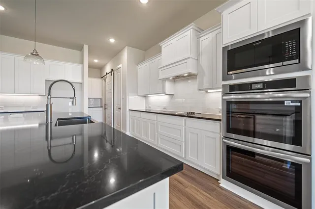 a kitchen with a sink stainless steel appliances and cabinets
