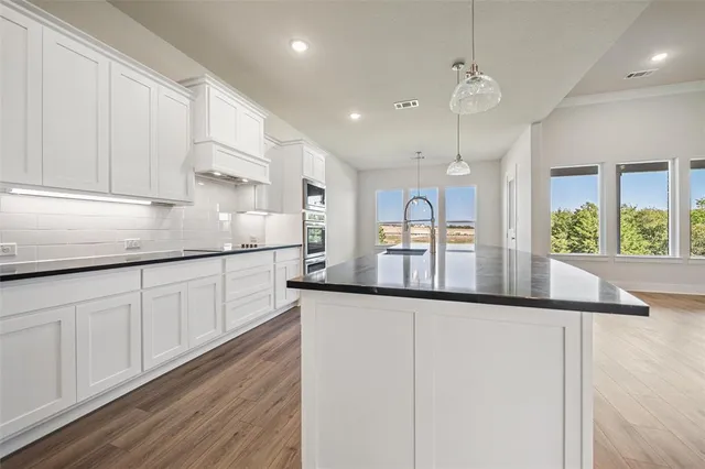 a kitchen with stainless steel appliances granite countertop a sink and cabinets