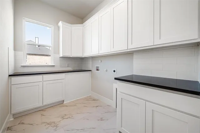 a kitchen with granite countertop white cabinets and a sink