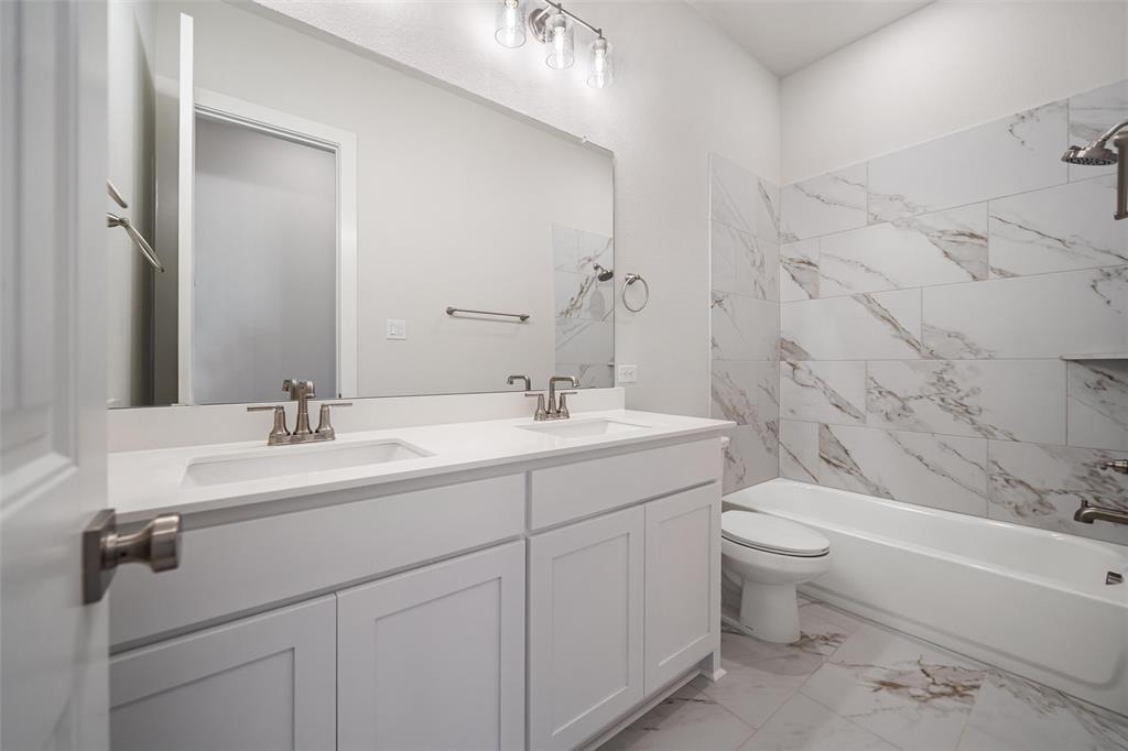 404 Indian Creek Road Van Alstyne, TX 75495 - Photo 28 of 40 a spacious bathroom with a double vanity sink a toilet and a bathtub