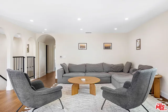 a living room with furniture and a wooden floor
