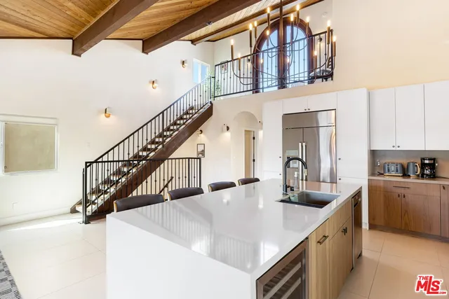 a kitchen with kitchen island granite countertop a sink a counter top space and cabinets