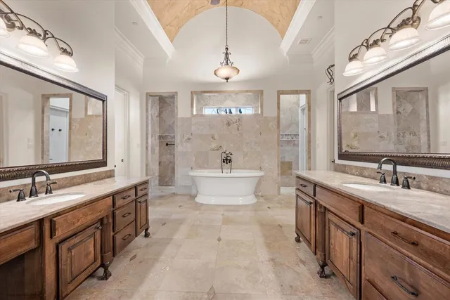 a spacious bathroom with a double vanity sink a mirror and a bathtub